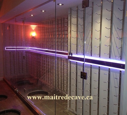 Gran cava de vino acristalada con soportes de pared para botellas e iluminación LED violeta.