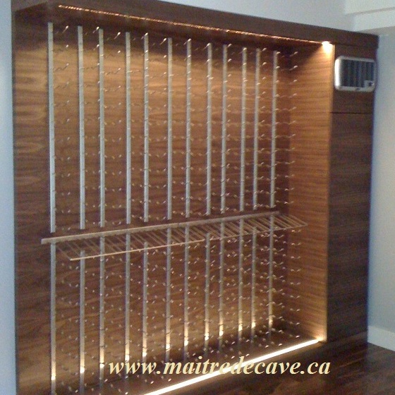 Muro de vino revestido en madera con soportes metálicos de pared para botellas e iluminación integrada.